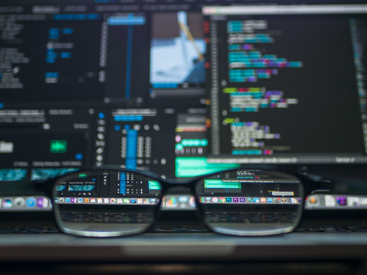 A developer's workspace with multiple monitors showing code, dashboards and API documentation
